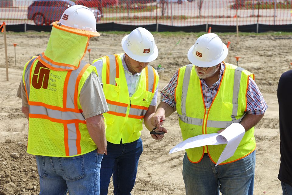 Construction team reviewing plans together on site