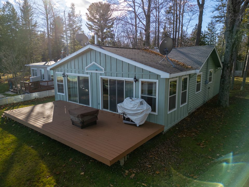 Lakefront cottage framed by mature trees